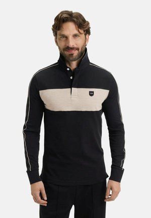 Polo shirt à manches longues noir et beige avec col, comportant une bande solide beige sur la poitrine et des détails en blanc sur les manches.