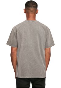 Grå bomulds t-shirt med en afslappet pasform, korte ærmer og rund hals. Har en vasket tekstur og synlige sømme langs kanterne.