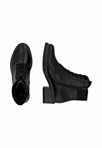 Botines de cuero negro hasta el tobillo con un diseño de cordones y cremallera lateral. Presentan un panel texturizado y un tacón bajo apilado. Acabado suave.