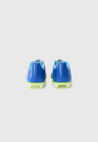 Le scarpe da calcio blu presentano un upper sintetico liscio, un colletto imbottito, accenti verdi e tacchetti bianchi per garantire aderenza su superfici erbose.