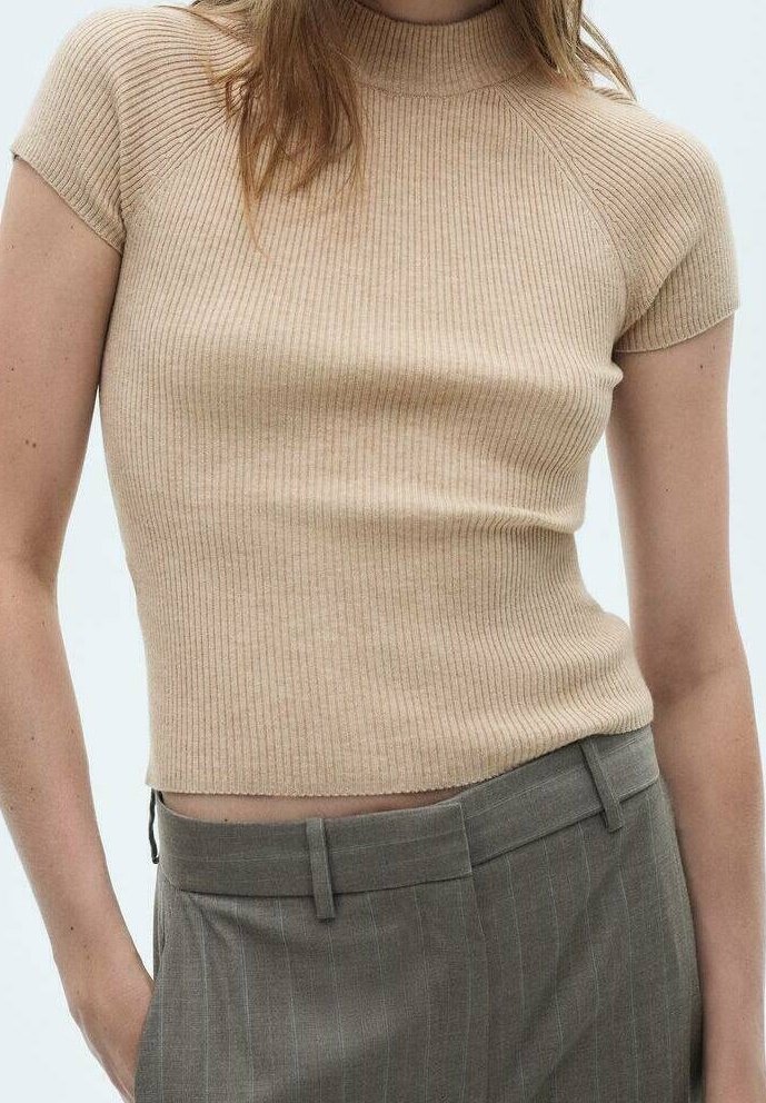 Haut en maille beige côtelé à manches courtes associé à un pantalon gris à rayures taille haute porté par une personne avec un bras visible.