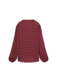 Blusa rossa a maniche lunghe con un motivo geometrico ripetuto di triangoli in bianco e blu navy. Tessuto morbido con una vestibilità ampia e orlo arrotondato.
