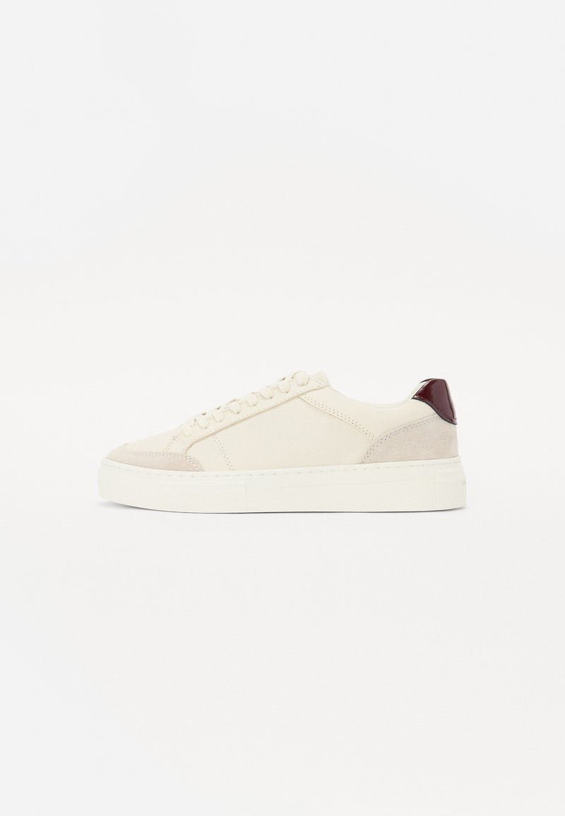 Tenisice s gornjim dijelom od krem kože, bež suedenim detaljima, tamnocrvenom petom i debelim bijelim gumeni potplat. Dizajn s vezicama.