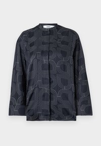 Blusa blu navy con un motivo geometrico bianco, dotata di colletto alla mandarina e maniche lunghe, realizzata in un tessuto liscio e lucido.