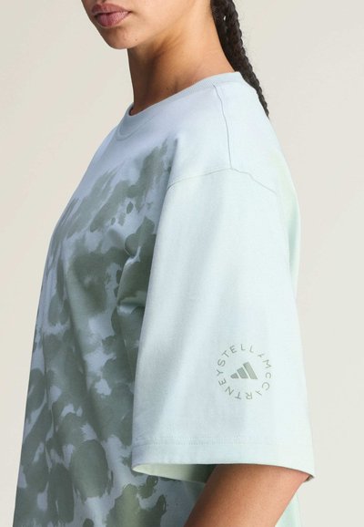 Kurzärmeliges T-Shirt in Minzgrün mit einem dezenten abstrakten Muster. Verfügt über einen Rundhalsausschnitt und ein Logo auf dem linken Ärmel. Weiches Baumwollmaterial.