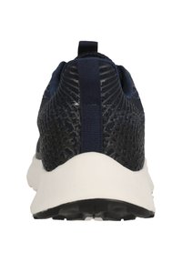 Laivastonsininen teksturoitu sneakeri valkoisella pohjalla, kantapään vetotappi ja hengittävä verkko-osi. Ominaisuuksiin kuuluu kuvioitu pinta pitoa varten.