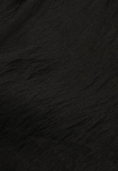 Μαύρο ύφασμα με ελαφρώς ζαρωμένη υφή και διακριτικό ματ φινίρισμα.