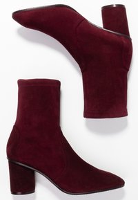 Botines de ante burdeos con punta estrecha y tacón cuadrado, con lados sin costuras y una textura suave.