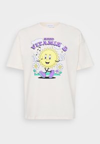 Cream-colored cotton t-shirt featuring a cartoon sun graphic with the text "Need Vitamin D," surrounded by flowers and music notes.