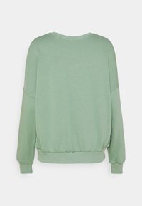 Sweat-shirt vert sauge à manches longues avec poignets côtelés, col rond et ourlet élastiqué, montré de dos sur un fond uni.