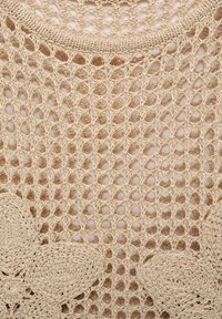 Beige crochet top with an open mesh pattern and floral accents. Features a round neckline and a textured, lightweight fabric.