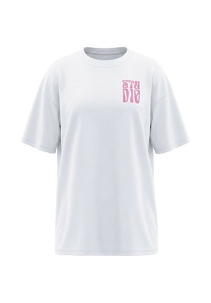 Camiseta blanca de gran tamaño con mangas cortas y texto estilizado en rosa "STUDIO" en la zona izquierda del pecho.