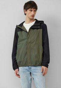 Lichte, bicolor jas met olijfgroene en zwarte panelen, een ritssluiting aan de voorkant, een verstelbare capuchon en elastische manchetten. Soepele textuur.