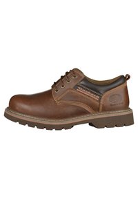 Chaussure en cuir marron avec un bout arrondi, des coutures détaillées, une semelle en caoutchouc robuste et un système de laçage. Présente une section de talon foncé contrastante.