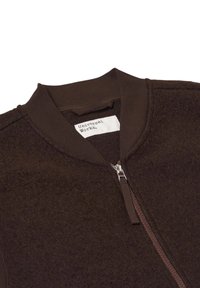 Giacca di pile marrone con zip frontale, colletto a costine e etichetta. Presenta una texture morbida e un design arrotondato e aderente.