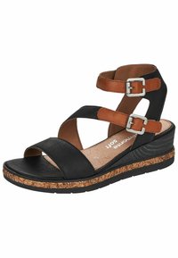 Sandale compensée noire et marron avec deux boucles argentées, bout ouvert et semelle texturée avec motif floral sur la semelle intermédiaire.