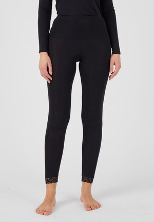 Leggings noirs au tissu lisse, taille haute, avec des détails en lace au bord des chevilles. Conçus pour le confort et la flexibilité.