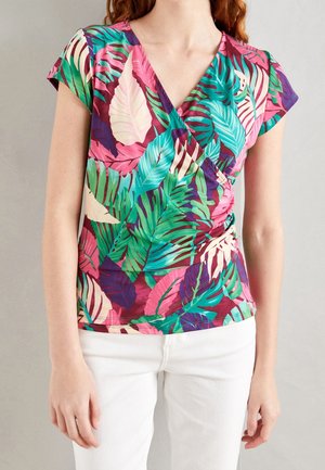 Chemise à manches courtes avec col en V et motif feuilles tropicales vibrantes, présentant des nuances de vert, rose et violet sur un tissu léger.