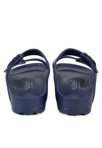 Sandales en plastique bleu marine avec deux brides ajustables et semelle texturée. Présente un logo de marque sur la semelle intérieure et une semelle à motif.