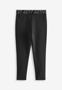 Zwarte actieve leggings van rekbaar materiaal met een middelhoge tailleband en "NEXT ACTIVE"-branding in grijs, en een aansluitend ontwerp tot de enkels.