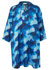 Blau bedruckte Tunika mit Kragen, Schnürung an der Vorderseite, langen Ärmeln und lockerer Passform. Sie zeigt ein Muster aus verschiedenen Blau- und Schwarztönen.