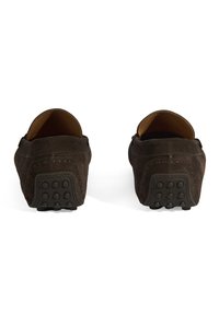 Dunkelbraune Wildlederslipper mit glatter Textur, praktischer Schlupfform und Gummisohlen, die mit kleinen, runden Griffmustern versehen sind.