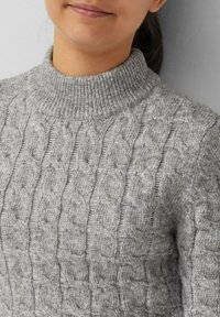 Grauer gestrickter Pullover mit hohem Rippkragen, der ein Kabelmuster und eine weiche Textur aufweist.