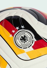 Krupan kadar bijele nogometne lopte s bojama njemačke zastave i logom Njemačkog nogometnog saveza s četiri zvjezdice iznad.