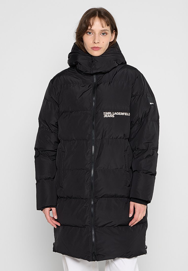 Doudoune noire avec un col montant, fermeture éclair à l'avant et boudins horizontaux. Présente le logo Karl Lagerfeld Jeans en blanc sur la poitrine.