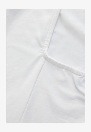 Witte katoenen stof met een gladde textuur, met een naad aan de linkerkant en een patch pocket aan de rechterkant, beide in een minimalistisch ontwerp.