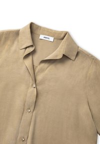 Khaki button-up shirt with a classic collar, soft texture, short sleeves, and a subtle sheen. Features a single chest pocket and minimalistic design.