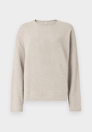 Suéter beige de manga larga con cuello redondo, textura suave y puños acanalados. El diseño es sencillo, con un ajuste relajado y sin adornos.