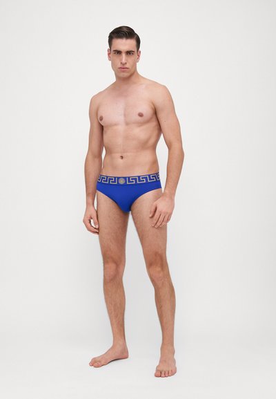 Blaue Schwimmbreifs mit einem dekorativen goldenen griechischen Schlüssel-Muster entlang des Bundes. Hergestellt aus glattem, dehnbarem Material für Komfort.