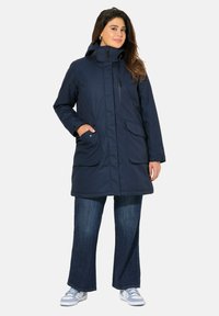 Marineblaue, isolierte Parka mit hohem Kragen, Reißverschlüssen und zwei großen Vordertaschen. Hat einen lockeren Schnitt und einen glatten, strukturierten Stoff.