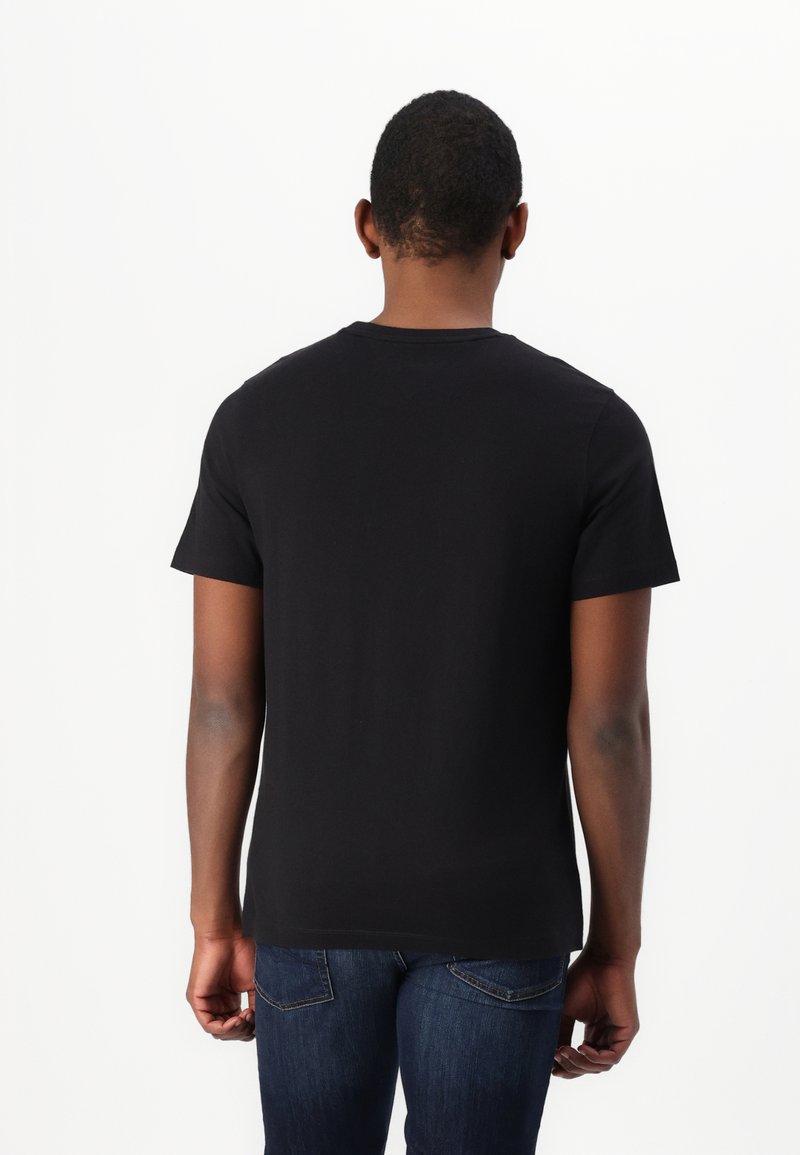 Czarna koszulka z krótkim rękawem, wykonana z bawełny, z okrągłym dekoltem, wyeksponowana z tyłu, pokazująca prosty dizajn i gładką teksturę.