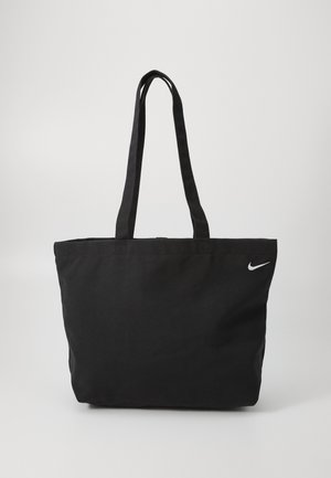 Geantă tote neagră din material textil, cu două bretele pentru umăr. Prezintă un logo alb Nike pe partea din față. Formă simplă, rectangulară.