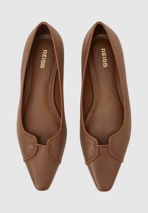 Barna bőr lapos cipők hegyes orral, finom dizájn részlettel a felsőrészen és sima belső béléssel. Arany logó a belsejében.