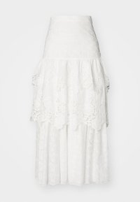 Falda blanca de capas hecha de algodón bordado, con detalles de encaje floral, cintura ajustada y una capa inferior texturizada con perforaciones.