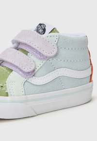 Baskets velcro vert menthe et lavande avec un motif en vague blanche, texture en daim doux et accent à talon orange ; semelle en caoutchouc.