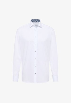 Hvid langærmet skjorte med knaplukning fortil, der har en kontrastfyldt blå mønstret inderskål og sølvfarvede knapper. Glat stof.