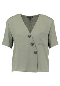 Kortärmad olivgrön blus med V-ringning, tre bruna knappar och en bröstficka. Tillverkad av lättviktsmaterial.