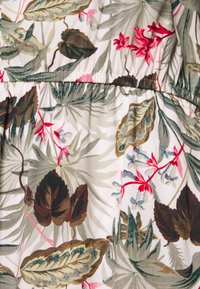 Tissu floral présentant diverses feuilles vertes et fleurs roses. Le motif comprend un fond crème clair avec des textures et couleurs subtiles.