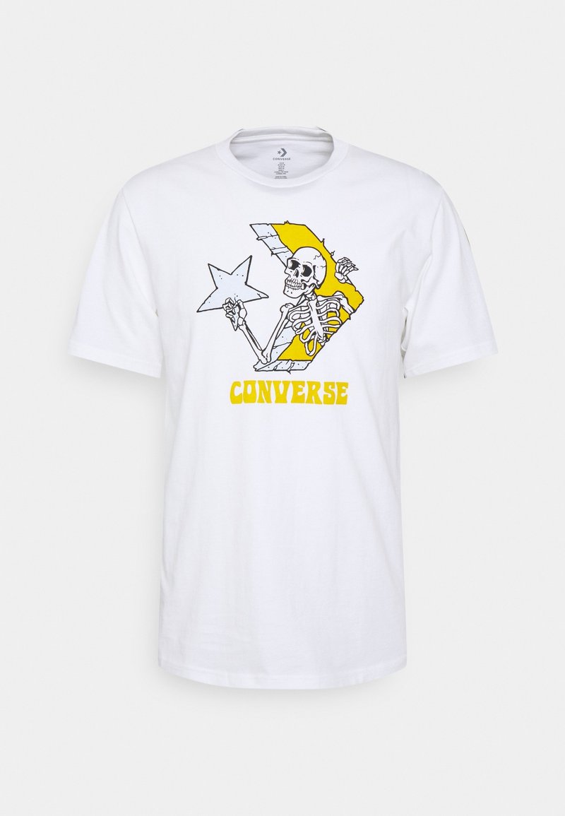 Camiseta blanca con un gráfico de un esqueleto sosteniendo una estrella dentro de un logotipo de chevron amarillo de Converse y el texto "CONVERSE" en amarillo debajo.