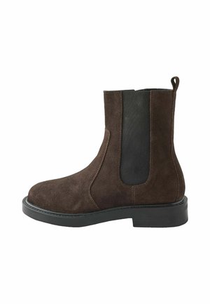 Bocanci din suede maro, cu panouri elastice pe laterale, bot rotund și o talpă robustă din cauciuc negru. Prevăzut cu un cârlig la spate pentru a fi ușor de încălțat.