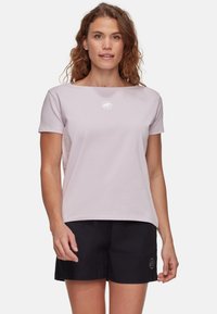 Lichtpaars T-shirt met korte mouwen en een boothals, voorzien van een klein wit logo. Gecombineerd met zwarte shorts, met een losse pasvorm.