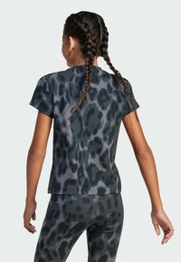 T-shirt leopardato in nero e grigio con maniche corte, realizzato in tessuto morbido; abbinato a leggings coordinati.