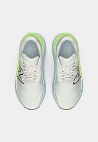 Um par de sapatilhas de corrida cinza claro e verde néon com tecido em malha e atacadores, vistas de cima sobre um fundo branco.