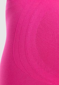 Farkut urheiluun, tiukasti istuvat ja kirkkaan vaaleanpunaiset, joissa on teksturoituja paneeleja ja sileitä osia, joissa on kaarevia viivoja lisäsuunnittelun yksityiskohtina.