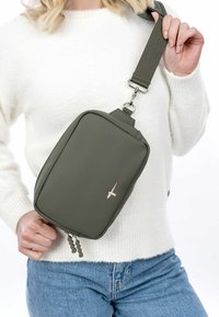 Õlipuu rohelise ükshaaval kantava kott siledast materjalist, ristkülikukujuline, millel on hõbedase riistvara rihmakinnitus ja ees väike logo.