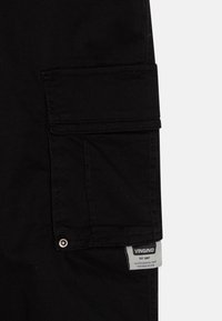Schwarze Cargo-Hosen mit einer Seitentasche, aus Baumwollmaterial, und einem gewebten Etikett mit "VINGINO" und dem Gründungsjahr. Flachnähte.